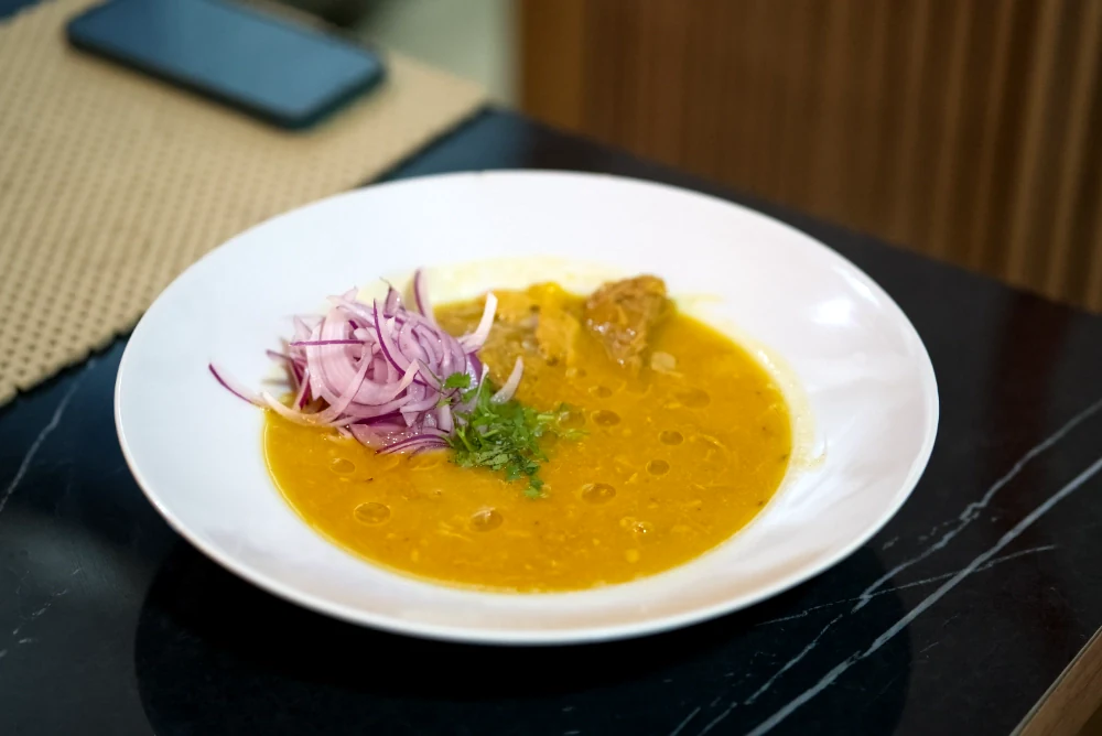Sopa tradicional con cebolla morada y cilantro servida en Caribe 2.0