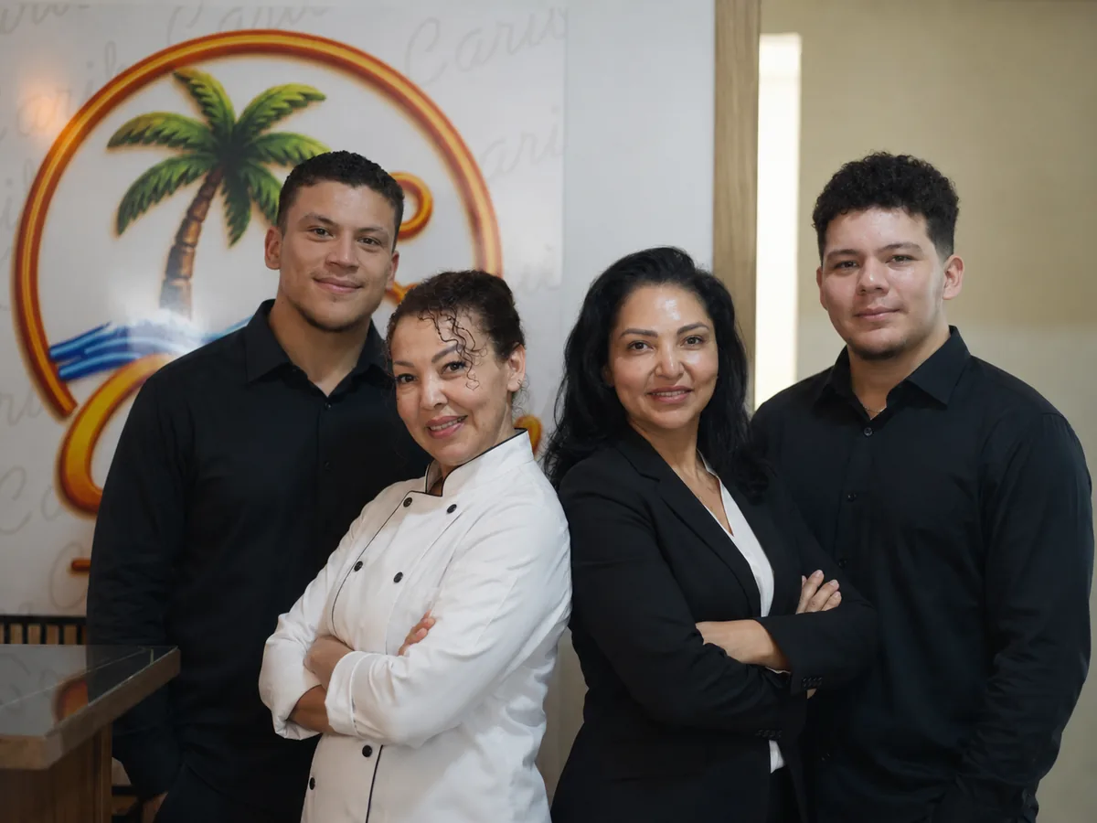 Equipo de Caribe 2.0 reunido frente al logotipo del restaurante